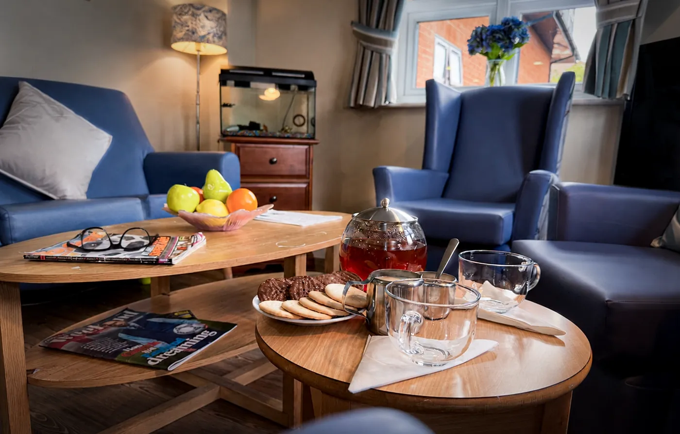 Fruit, biscuits and a pot of tea on a coffee table in the lounge at Ashbrook Nursing Home